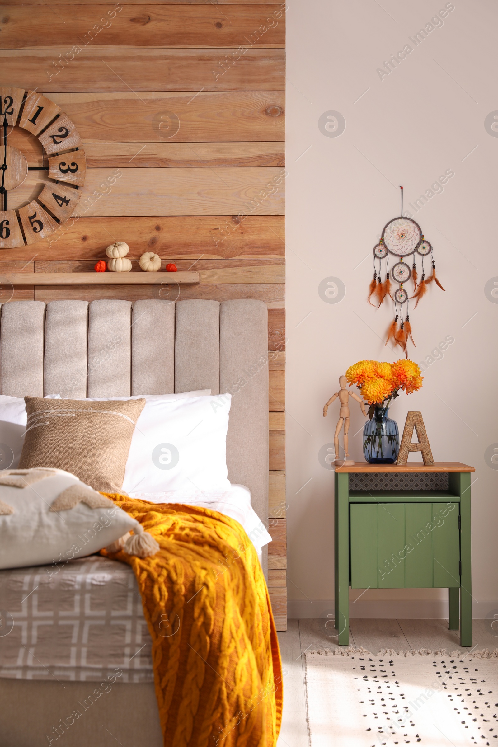 Photo of Beautiful dream catcher hanging near bed in stylish room interior