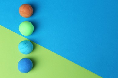 Different bright play dough on color background, flat lay. Space for text