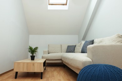 Photo of Attic room interior with slanted ceiling and furniture