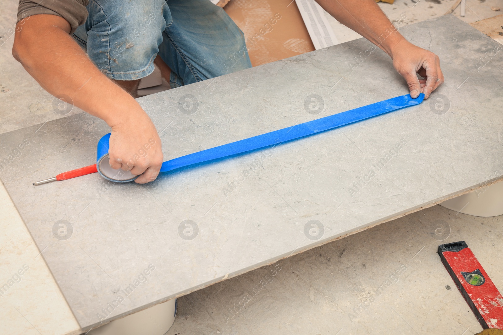 Photo of Worker making socket hole in tile indoors, closeup