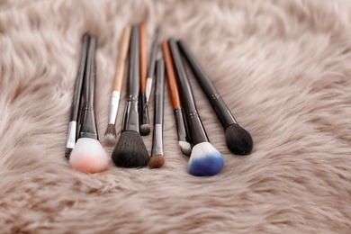 Photo of Different makeup brushes on faux fur