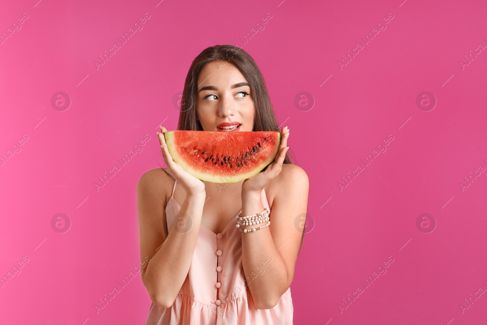 Photo of Beautiful young woman posing with watermelon on color background