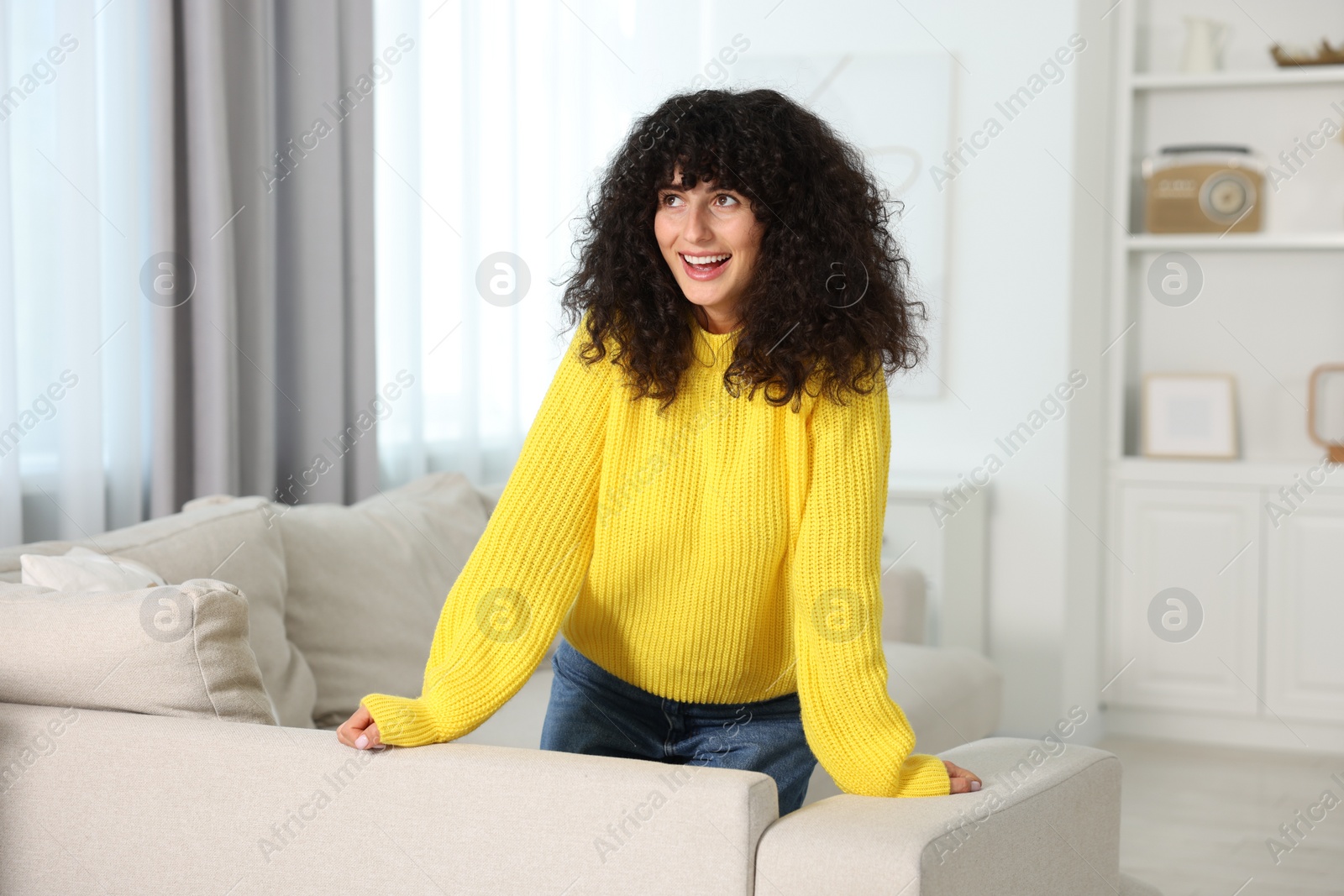 Photo of Happy young woman in stylish yellow sweater indoors