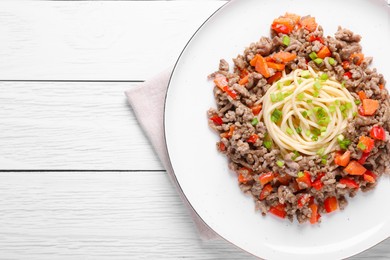 Photo of Tasty minced meat with spaghetti, vegetables and green onion on white wooden table, top view. Space for text