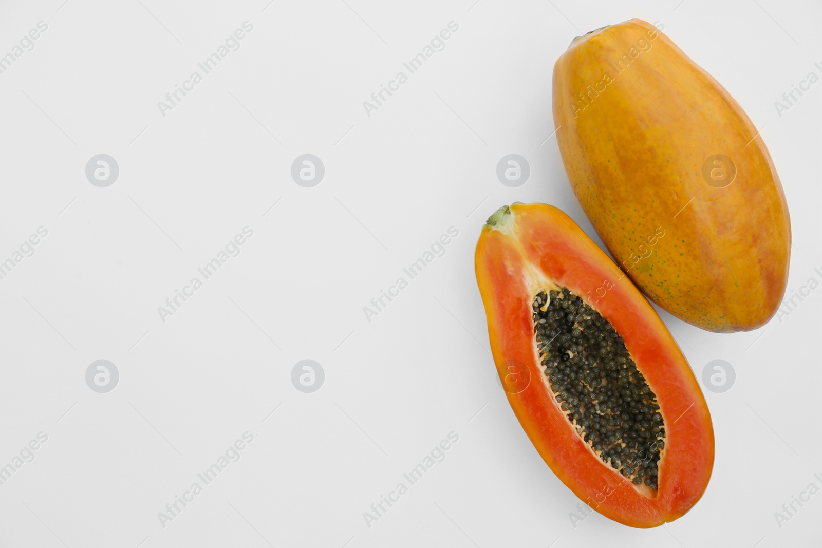 Photo of Fresh ripe papaya fruits on white background, flat lay. Space for text