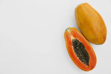 Photo of Fresh ripe papaya fruits on white background, flat lay. Space for text