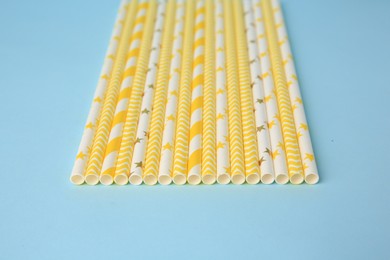 Photo of Many paper drinking straws on light blue background