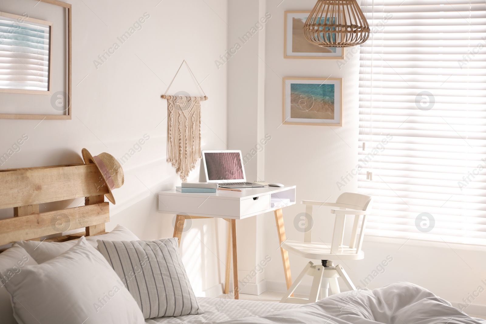 Photo of Stylish room interior with workplace and bed