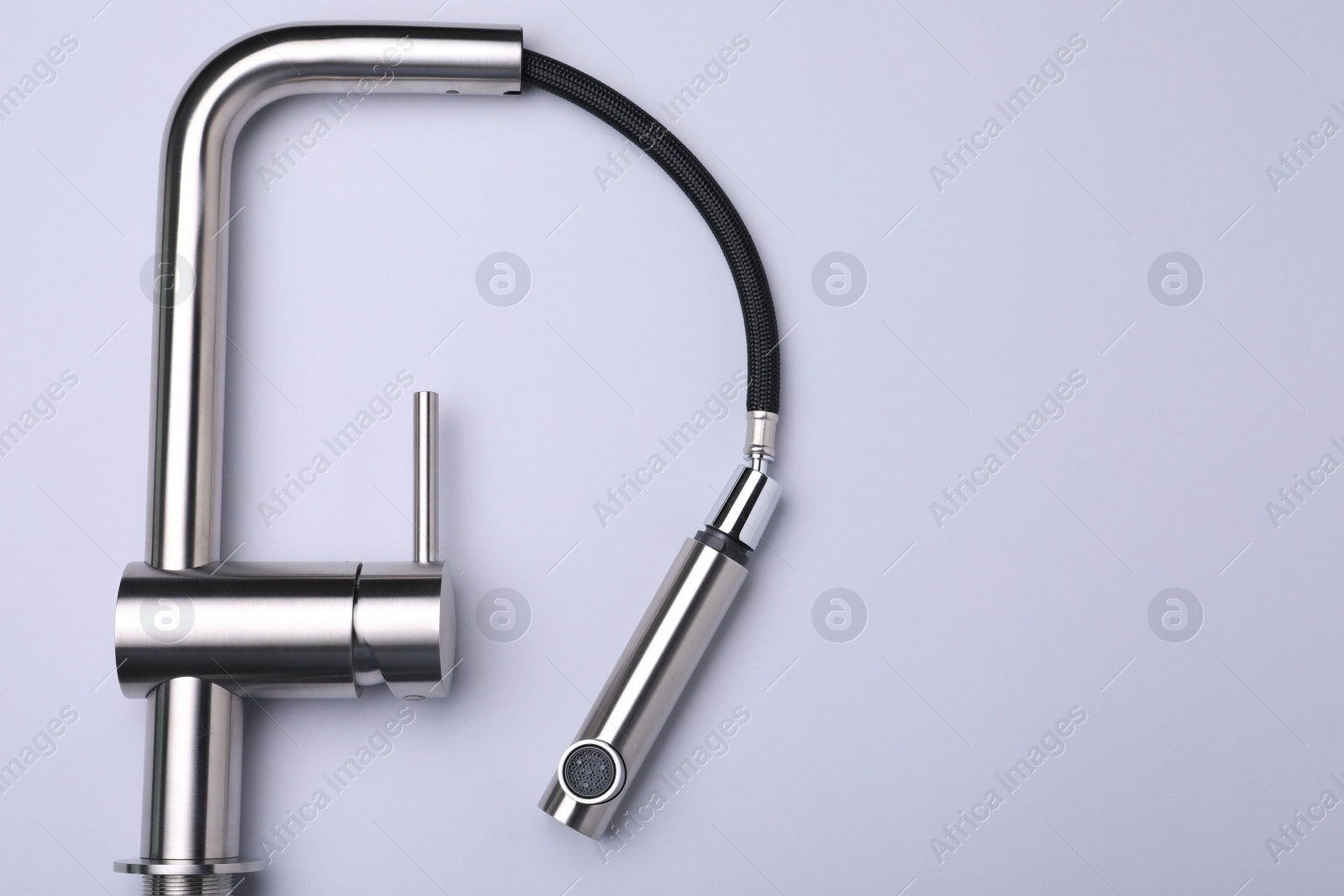 Photo of Modern pull out kitchen faucet on grey background, top view. Space for text