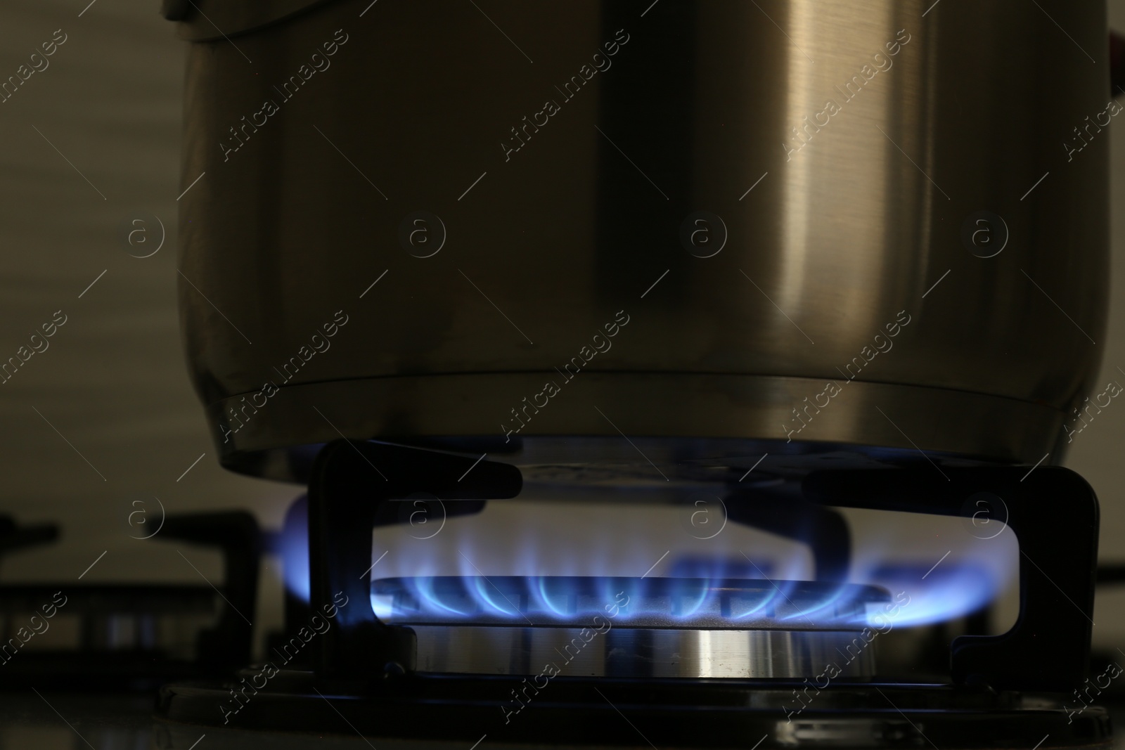 Photo of Pot on modern gas cooktop in kitchen, closeup