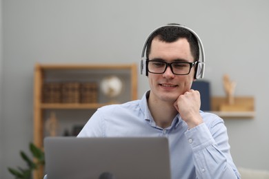 E-learning. Young man using laptop during online lesson indoors