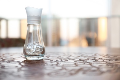 Photo of Air freshener on wooden table against blurred background