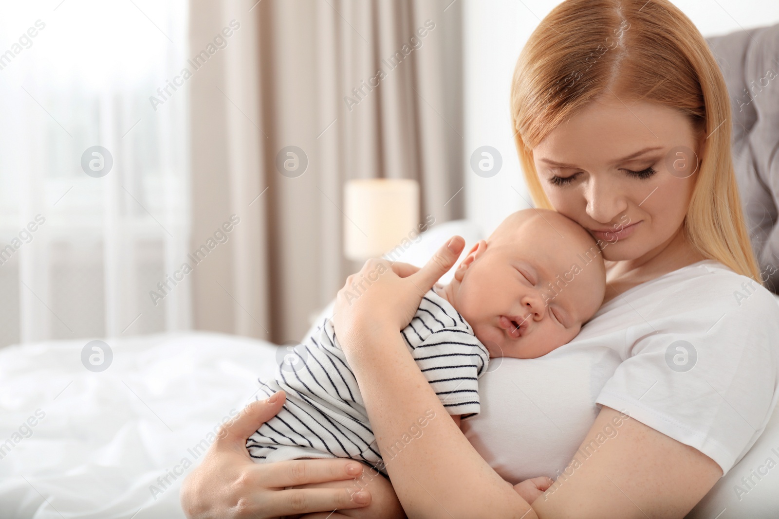 Photo of Mother with her sleeping baby in bedroom