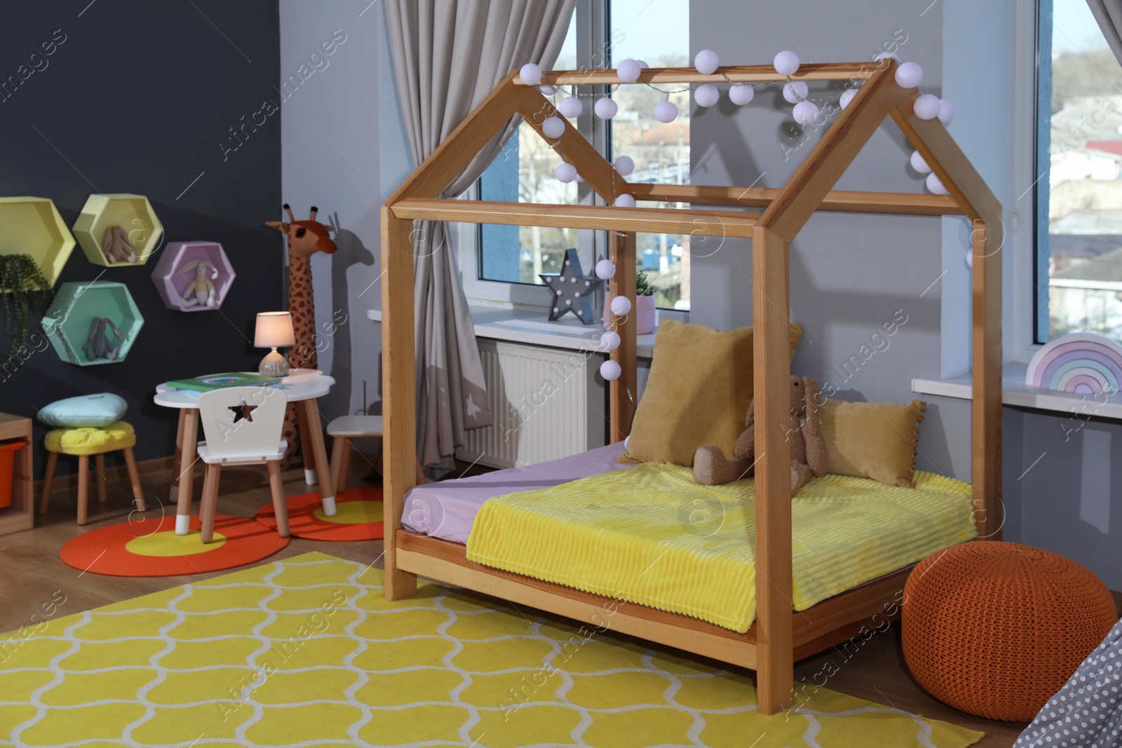 Photo of Stylish child room interior with comfortable house bed and toys