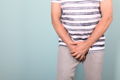 Photo of Mature man with urological problems suffering from pain on color background