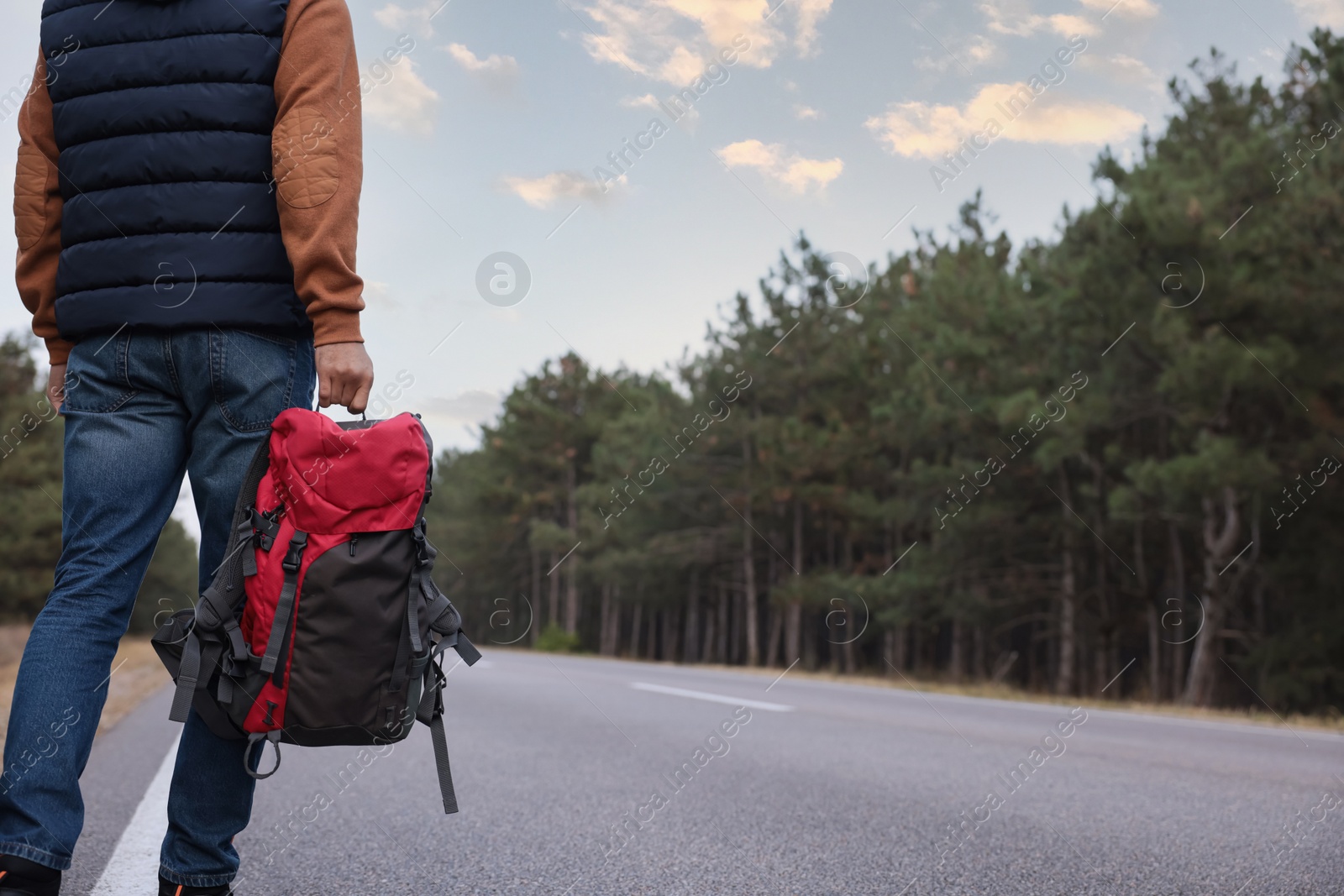 Photo of Man with backpack going along road, closeup
