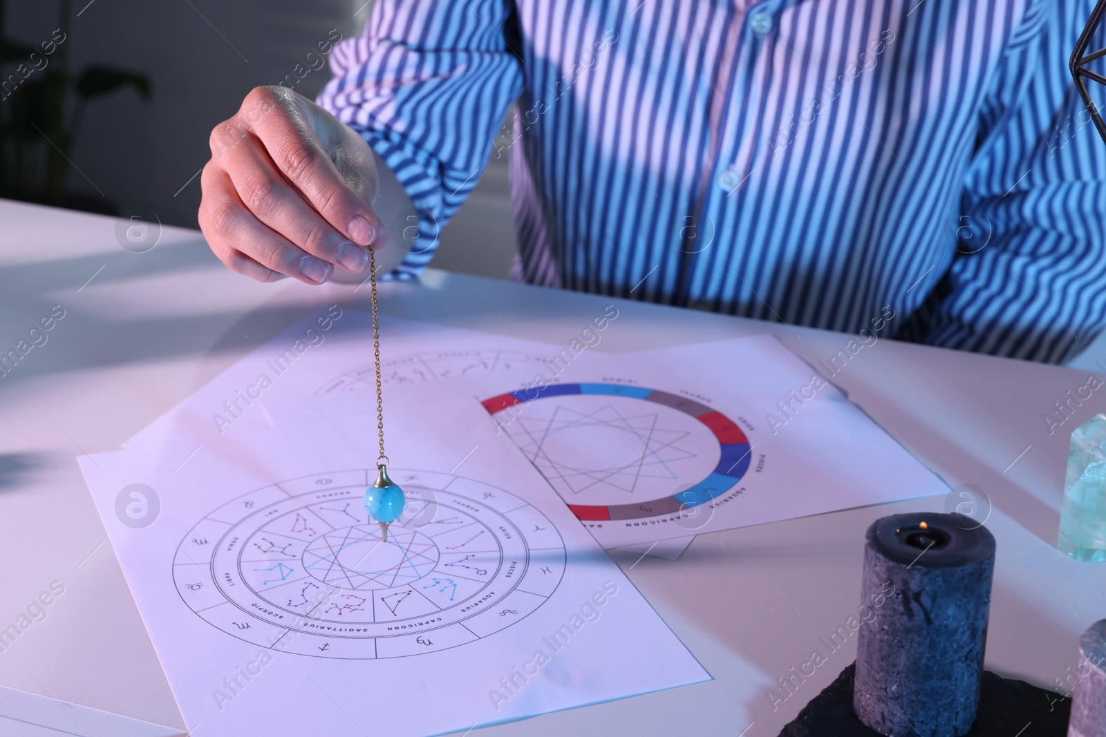 Photo of Astrologer predicting future with natal charts at table, closeup