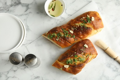 Flat lay composition with homemade garlic bread on table