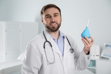 Doctor holding rubber enema in examination room
