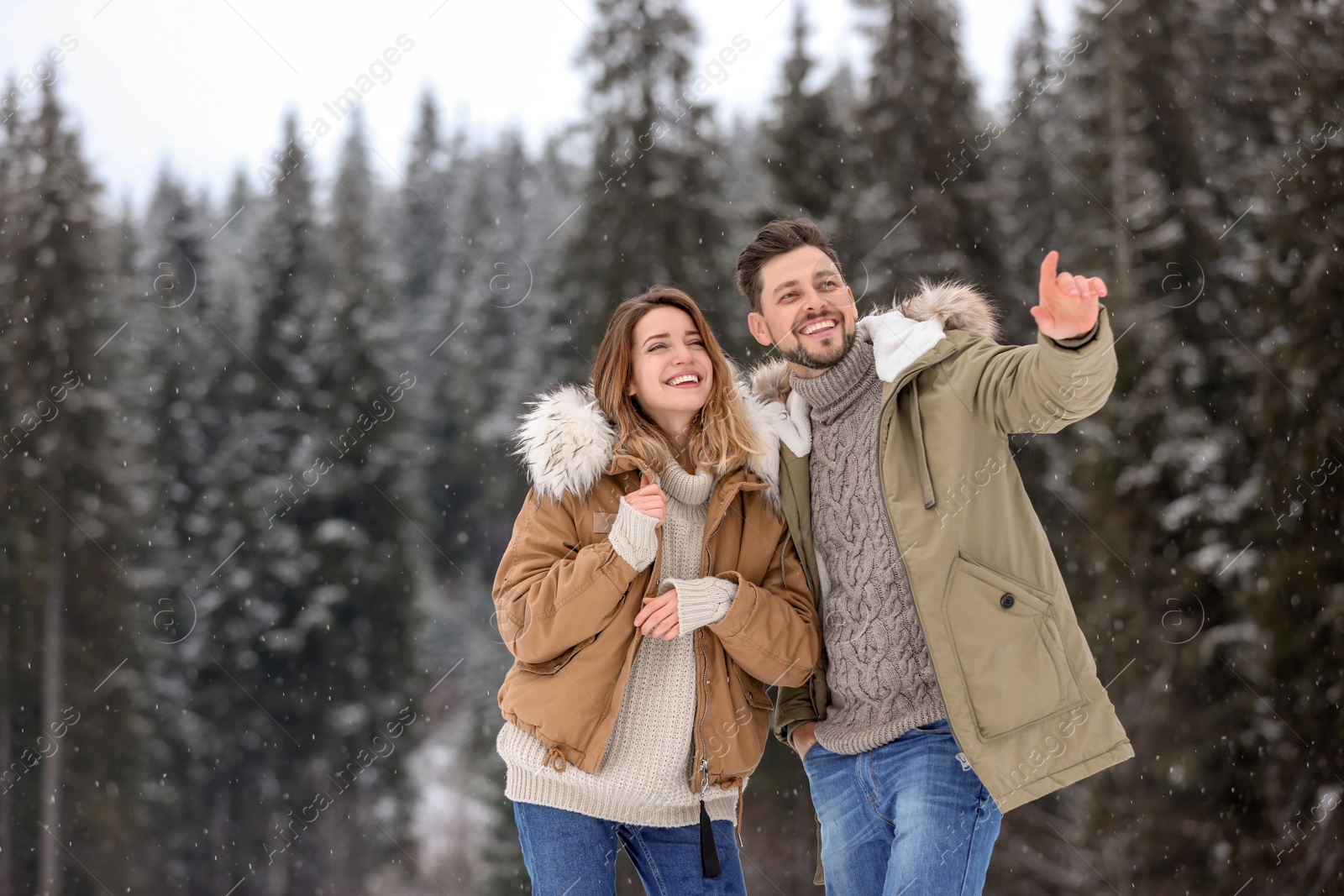 Photo of Couple spending time outdoors on snowy day, space for text. Winter vacation