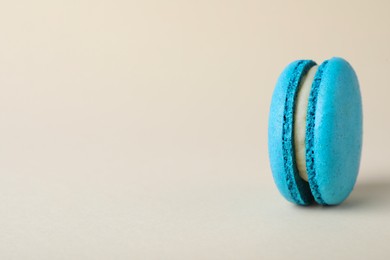 Photo of Delicious light blue macaron on beige background. Space for text