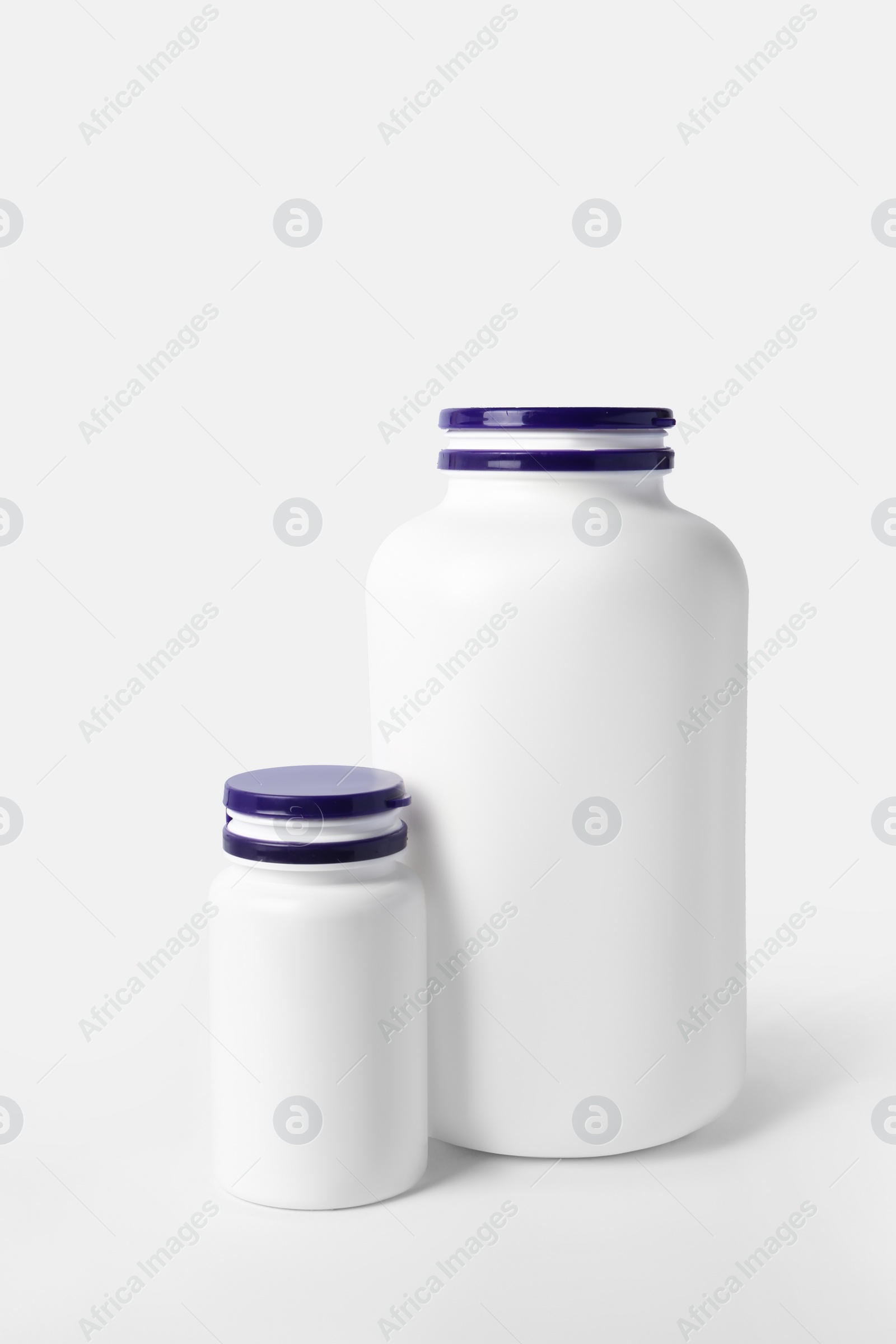 Photo of Closed plastic medicine bottles on white background. Medicament