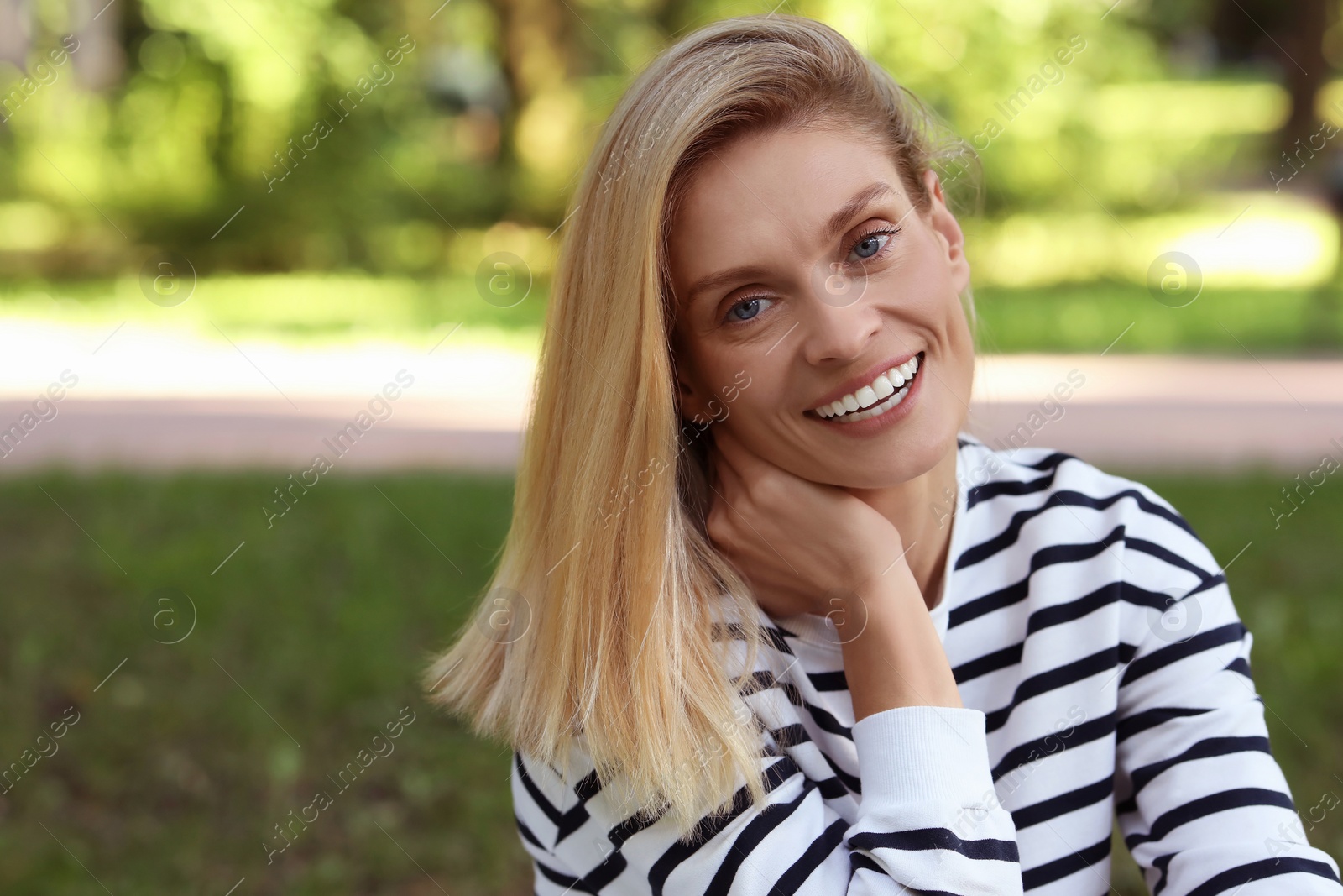 Photo of Portrait of happy woman in casual clothes outdoors. Space for text. Attractive lady smiling and posing for camera