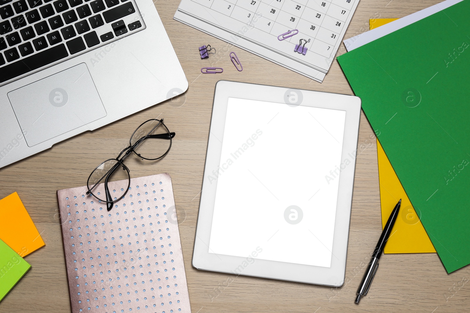 Photo of Modern gadgets, glasses and office stationery on wooden table, flat lay. Distance learning