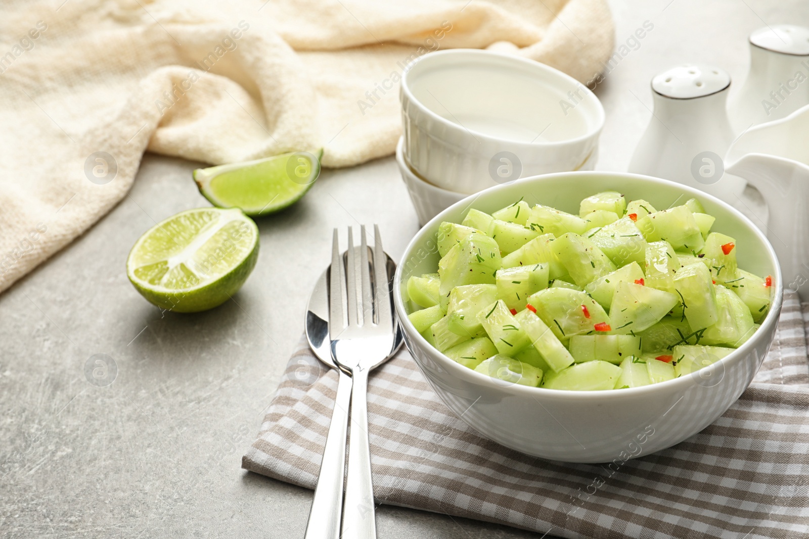 Photo of Delicious cucumber salad in bowl served on table. Space for text