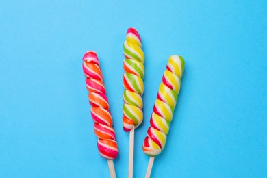 Sweet lollipops on light blue background, flat lay