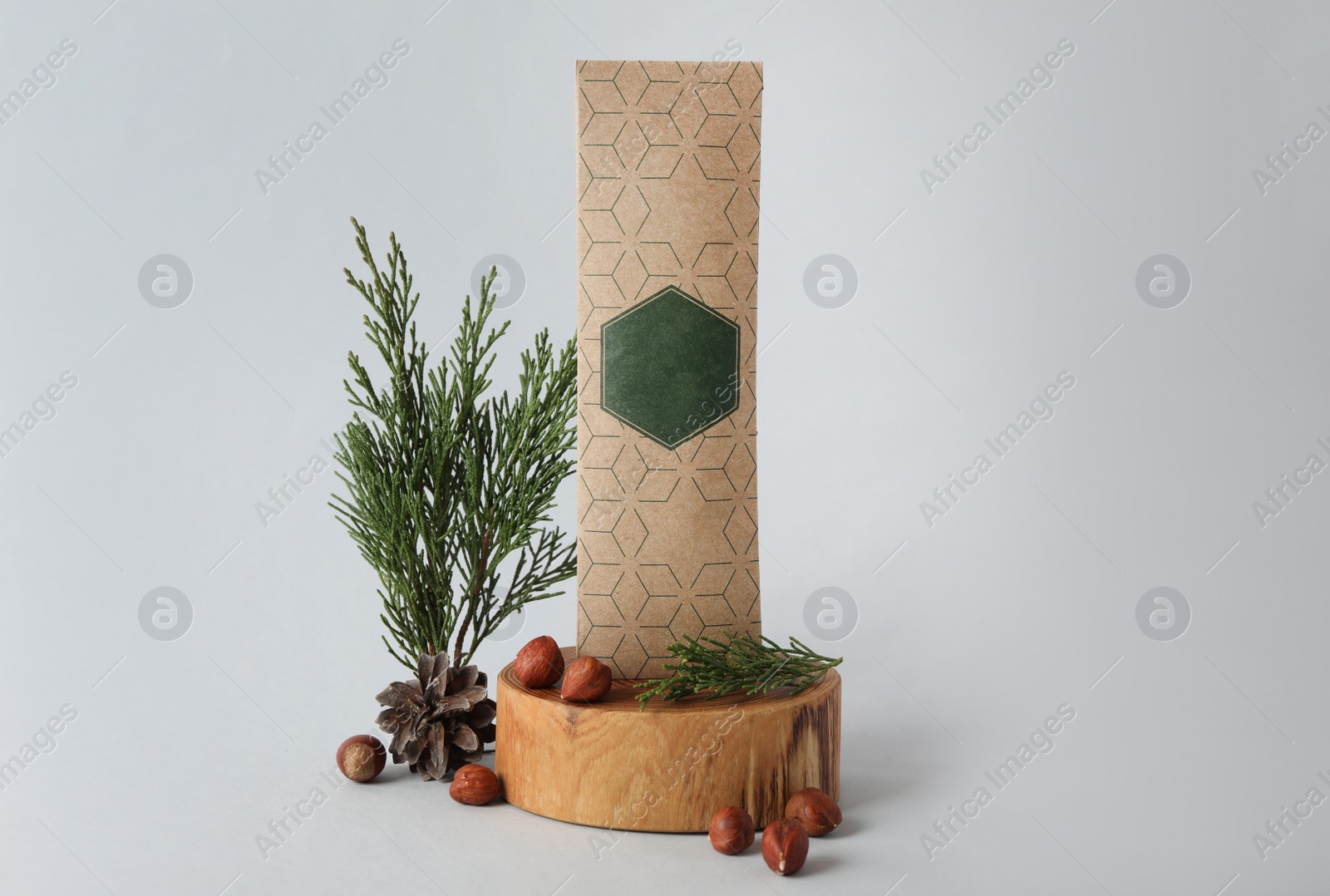 Photo of Scented sachet, hazelnuts and fir branches on grey background