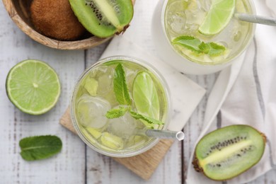 Photo of Refreshing drink with kiwi and ingredients on white wooden table, flat lay