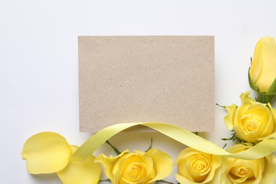 Photo of Beautiful yellow roses, petals, ribbon and blank card on white background, flat lay. Space for text
