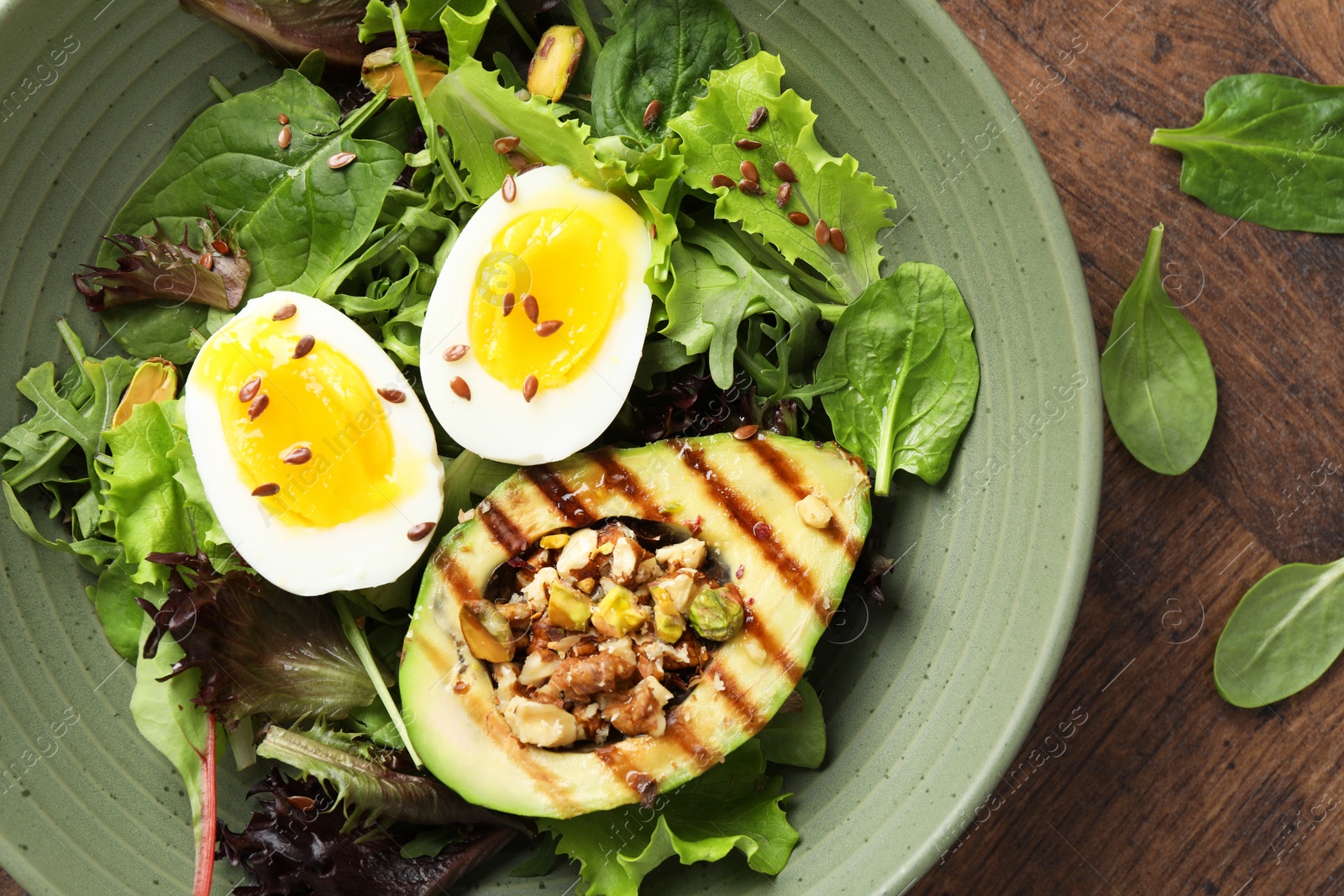 Photo of Healthy dish high in vegetable fats on wooden table, top view