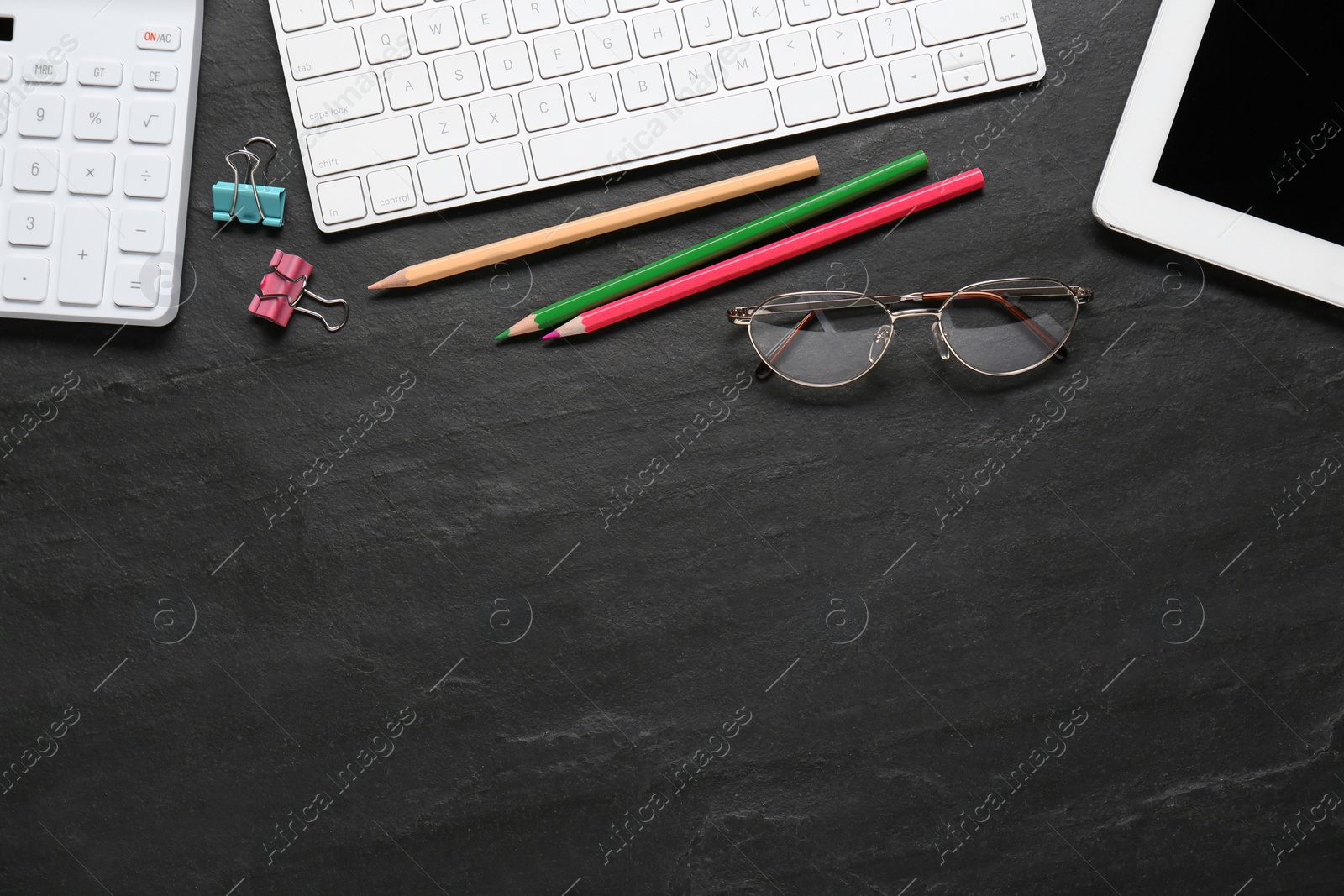 Photo of Stationery, glasses and computer keyboard on black table, flat lay. Space for text