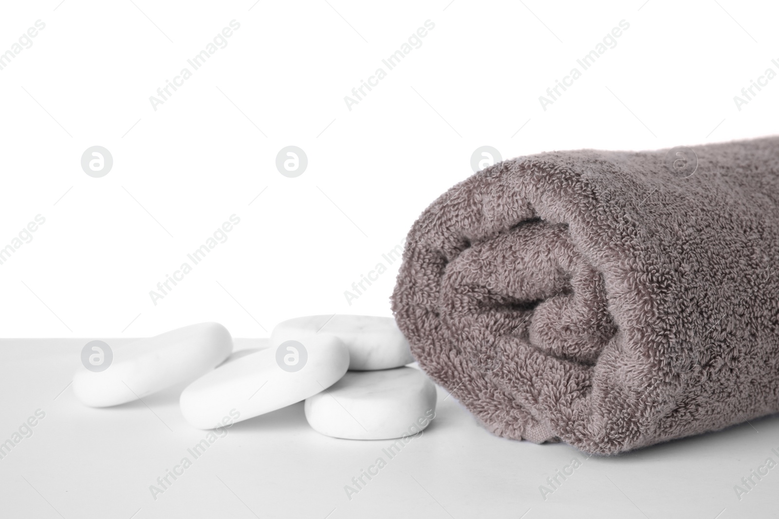 Photo of Soft towel and marble spa stones isolated on white