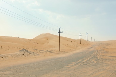 Photo of Electricity transmission line near road in desert