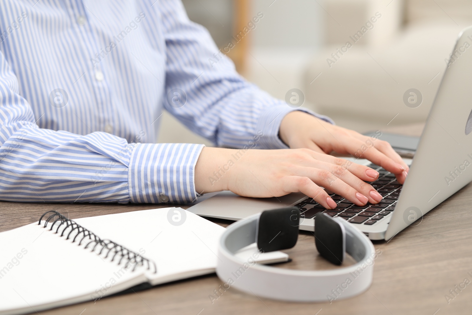 Photo of E-learning. Woman using laptop during online lesson at table indoors, closeup