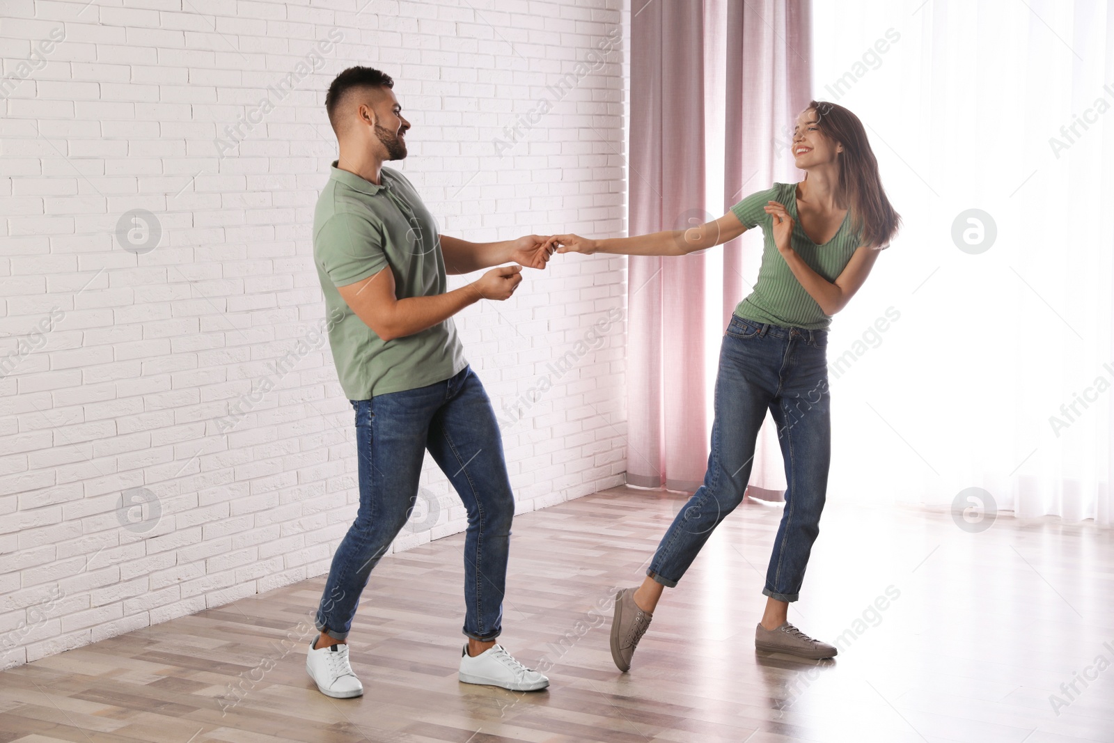 Photo of Lovely young couple dancing together at home