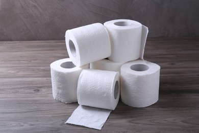 Photo of Soft toilet paper rolls on wooden table