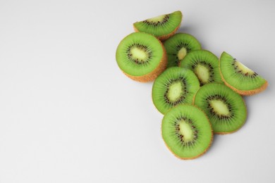Cut fresh ripe kiwis on white background, above view. Space for text