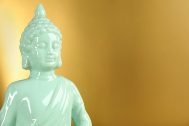 Buddha statue on golden background, closeup. Space for text