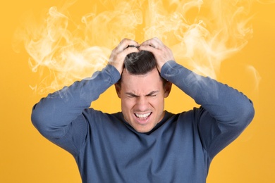 Stressed and upset young man on yellow background