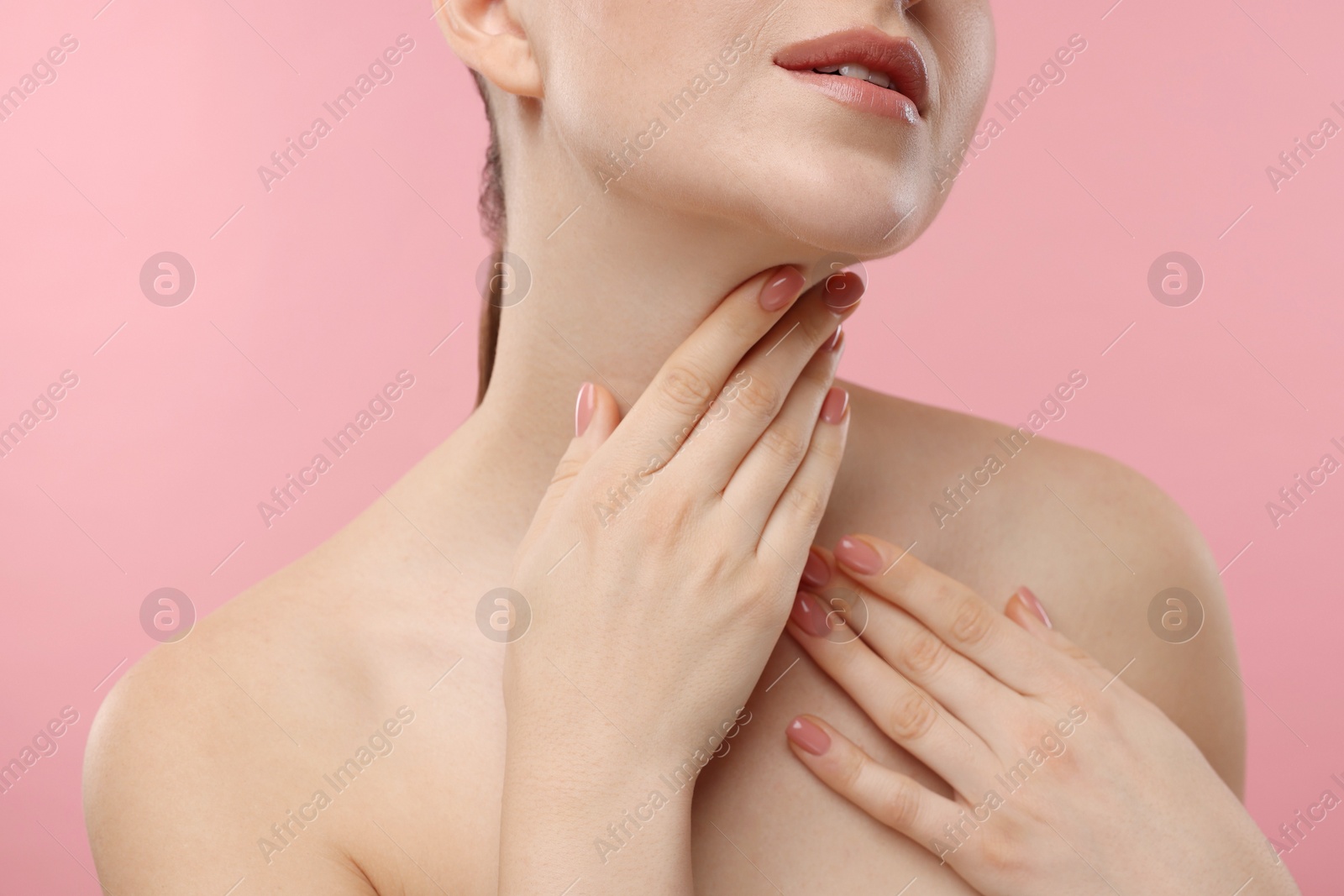 Photo of Woman touching her neck on pink background, closeup