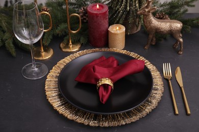 Photo of Festive place setting with beautiful dishware, cutlery and fabric napkin for Christmas dinner on grey table