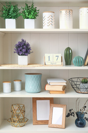 White shelving unit with plants and different decorative stuff