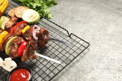 Delicious shish kebabs with vegetables on grey textured table. Space for text