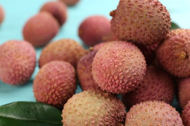 Photo of Fresh ripe lychee fruits on light blue table, closeup