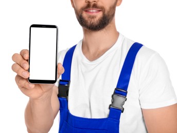 Photo of Professional repairman in uniform showing smartphone on white background, closeup
