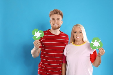 Photo of Woman and young man with recycling symbols on blue background